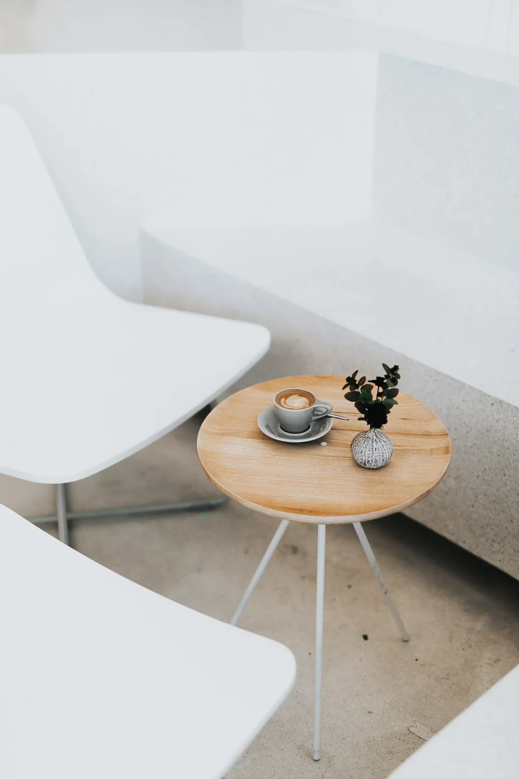 Espace de conversation avec fauteuils blancs et table basse ronde